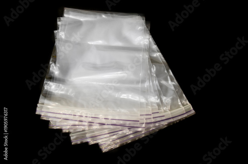 Transparent plastic zip lock bags stacked on black background, isolate
