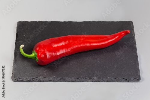 Vászonkép Whole sweet red Kapia pepper on black flat slate plate