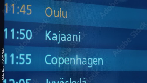 Flight schedule display board showing departure times for Kemi/Tornio, Oulu, Kajaani, Copenhagen, and Jyvaskyla in a modern airport terminal setting