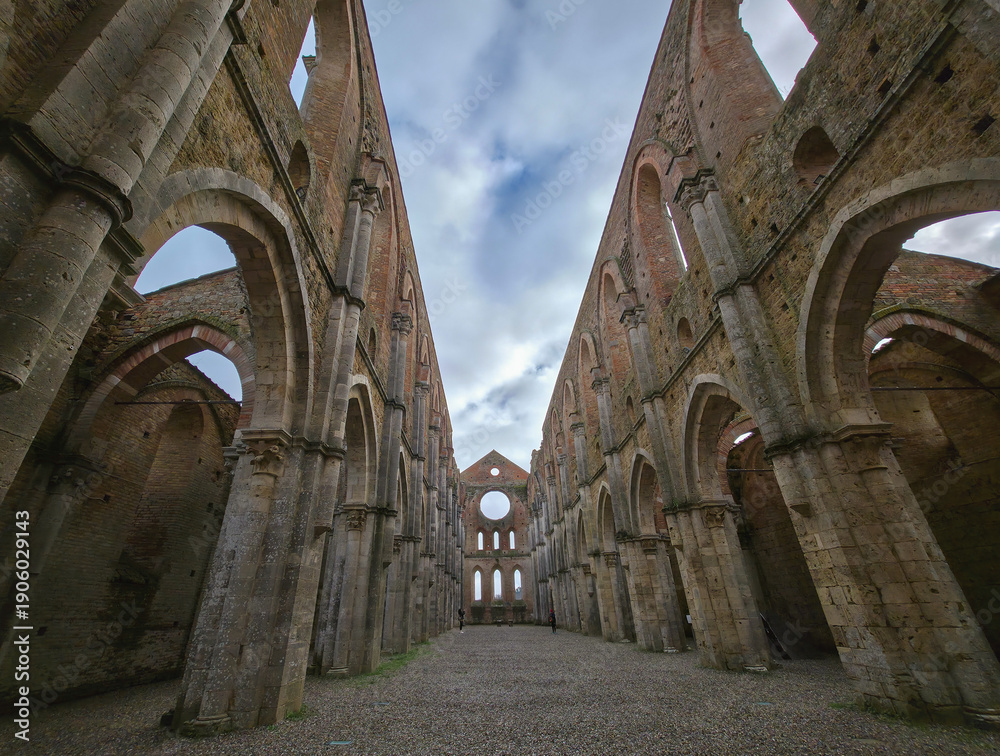 Fototapeta premium The roofless Gothic interior of the magnificent Abbazia di San Galgano in Tuscany, Italy, viewed from inside, leading to a circular window