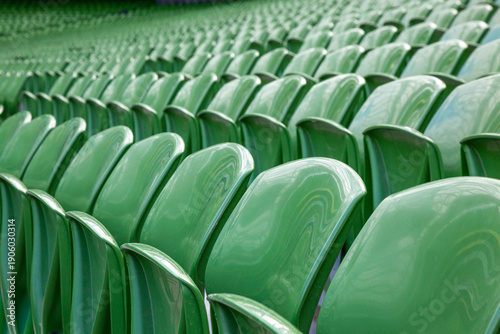 Rows of empty green plastic seats in a sports stadium