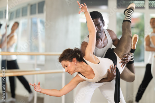 Photos Rehearsing ballet movements in a dance studio - man and woman performing adagio