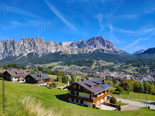 фотографія Peaceful and scenic view of the alpine town and surrounding Dolomites mountains under a blue sky