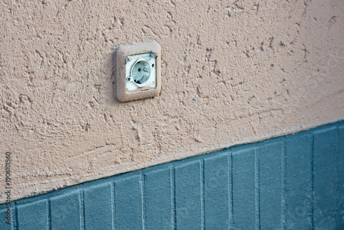 Beige facade outlet integrated into wall with matching paint.