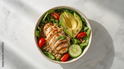 Ultra realistic flat lay photograph of a healthy food bowl with grilled chicken breast, fresh avocado slices, cherry tomatoes, cucumber, quinoa, and mixed greens.
