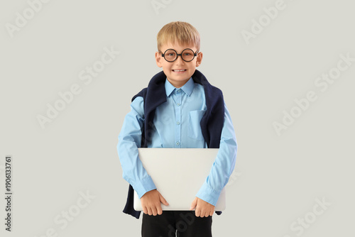 Little schoolboy with lapto...