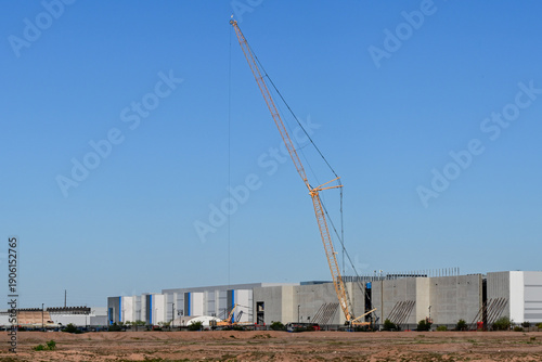 Quadro su tela Large industrial building complex under construction with crane at expanding dat