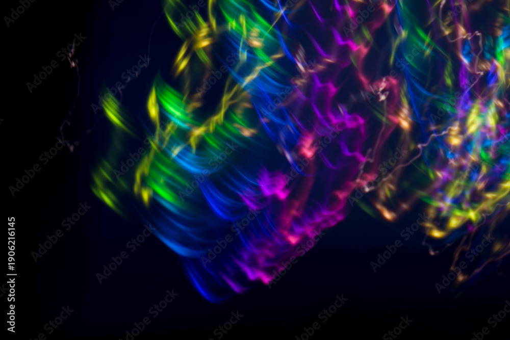 Fototapeta premium Abstract bright pink light streaks and glowing particles on a black background, ideal for futuristic, energetic, or festive designs