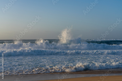 Valokuva An explosion from the ocean creates a vibrant beach atmosphere