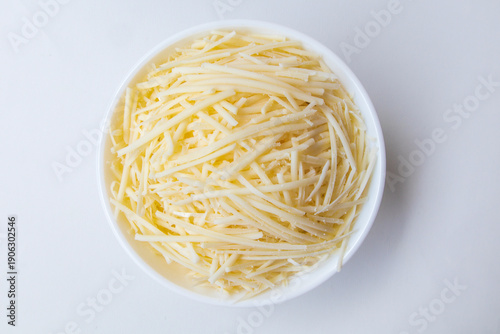 Photos Grated cheese in a bowl isolated on white