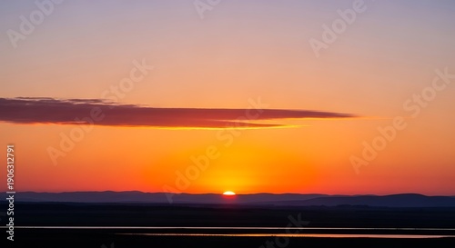 Beautiful Orange and Purple Sunset with Glowing Sun on Clear Horizon