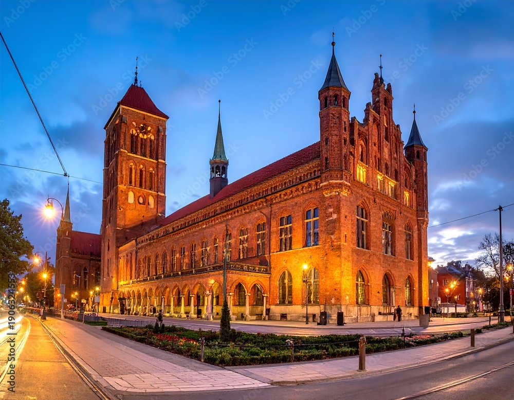 Fototapeta premium A large brick building with towers and spires at dusk