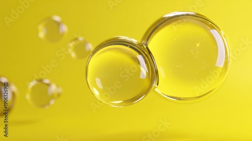 Transparent oil bubbles float against a vibrant yellow background, highlighting their smooth, spherical shapes and reflective surfaces.