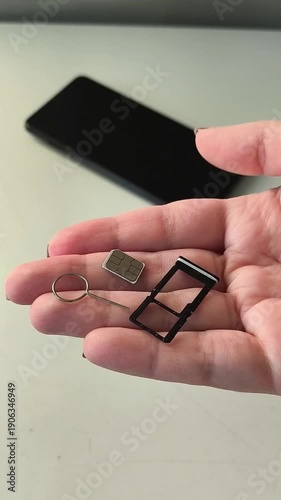 SIM card, SIM tray and key in hand against the background of the phone. Mobile Internet, communication