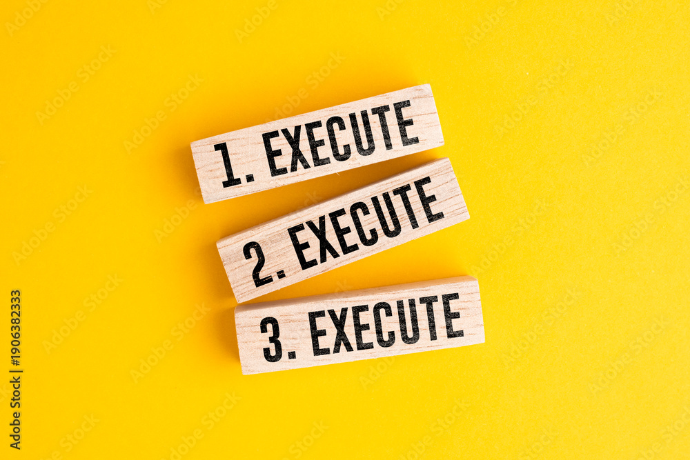 Naklejka premium Wooden block dengan tiga pengulangan kata execute, execute, dan execute. konsep yang konsisten