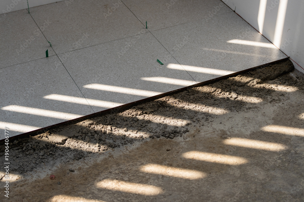 Fototapeta premium Tile installation process in a room interior work bright environment close-up view