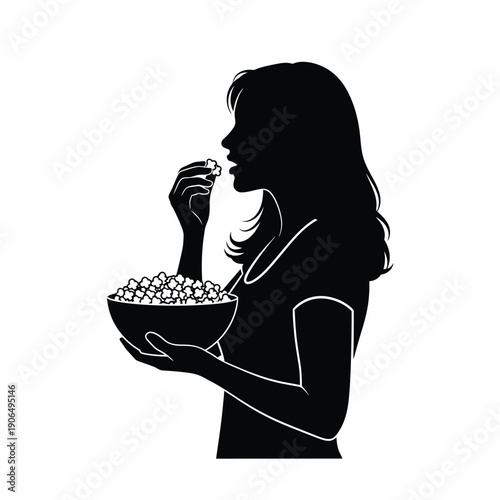 Silhouette of a woman eating popcorn from a bowl