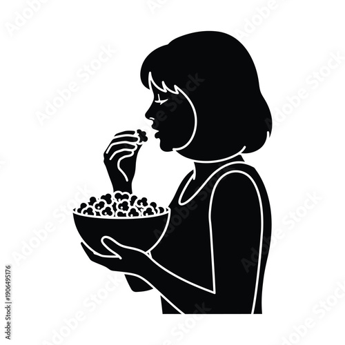 Silhouette of a woman eating popcorn