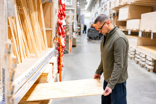 Man selecting timber (plywood) in hardware store