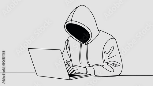 Anonymous hacker in a hooded sweatshirt using a laptop computer