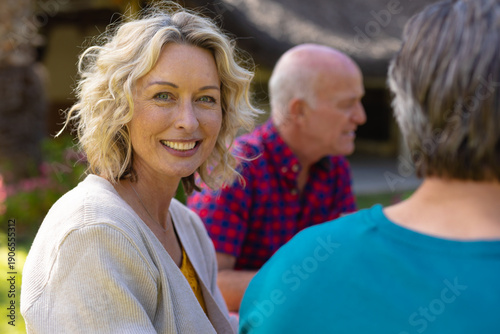 Quadro su tela Portrait of blond senior caucasian woman sitting with family in the garden