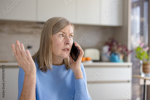 Canvastavla Senior woman looking concerned while talking on a smartphone, making a worried g