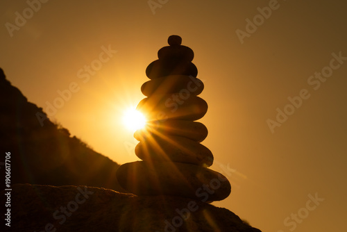 Balance stones sunset silhouette of a stacked cairn against a vibrant golden sky representing spirituality and zen concepts
