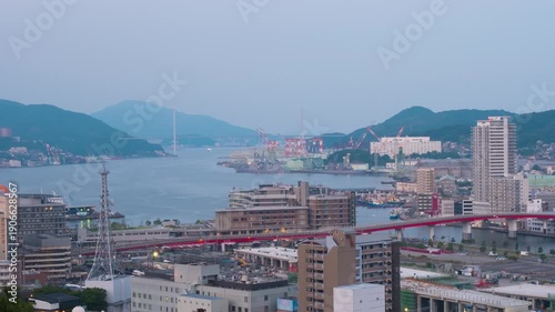 Nagasaki, Japan. Aerial timelapse made from a hill in Nagasaki, Japan, with a view over the entire center, including the bay and the hills. Cloudy and sunny morning in summer, panning video