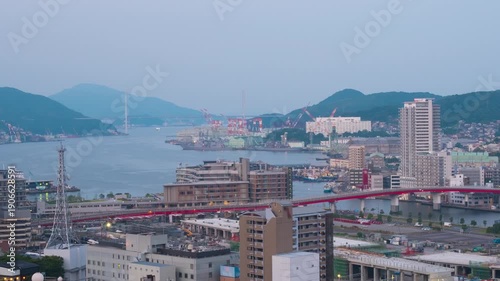 Nagasaki, Japan. Aerial timelapse made from a hill in Nagasaki, Japan, with a view over the entire center, including the bay and the hills. Cloudy and sunny morning in summer