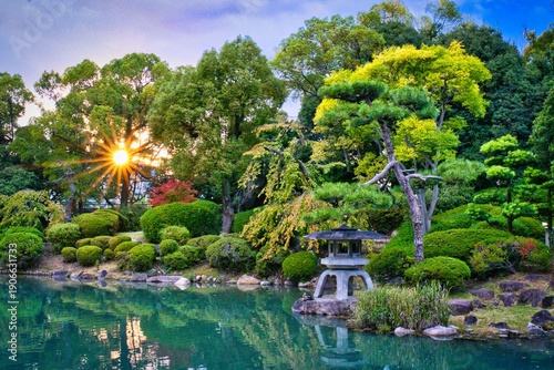 Autumn Sunset Flare Through Red Maple Leaves in Osaka Castle Japanese Garden at Main Palace Area