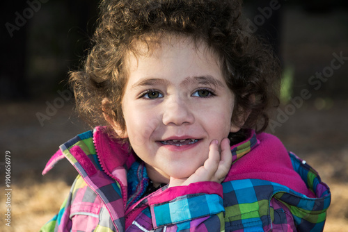 Autumn in the woods a little curly girl laughing.