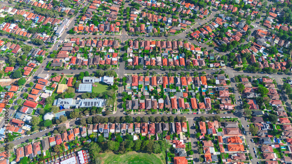 Fototapeta premium Panoramic Aerial Drone view of Inner Western Suburbs of Sydney housing, roof tops, the streets and the parks, the roads and trees of Ashbury Ashfield Burwood Summer Hill Canterbury and Campsie in Sydn