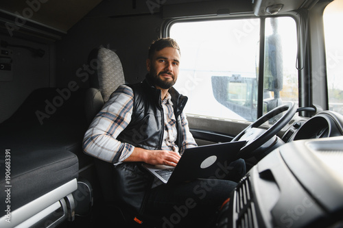 Fotografie Truck driver networking with laptop inside cab