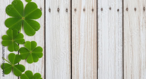 A serene arrangement of green clover leaves on a rustic white wooden background