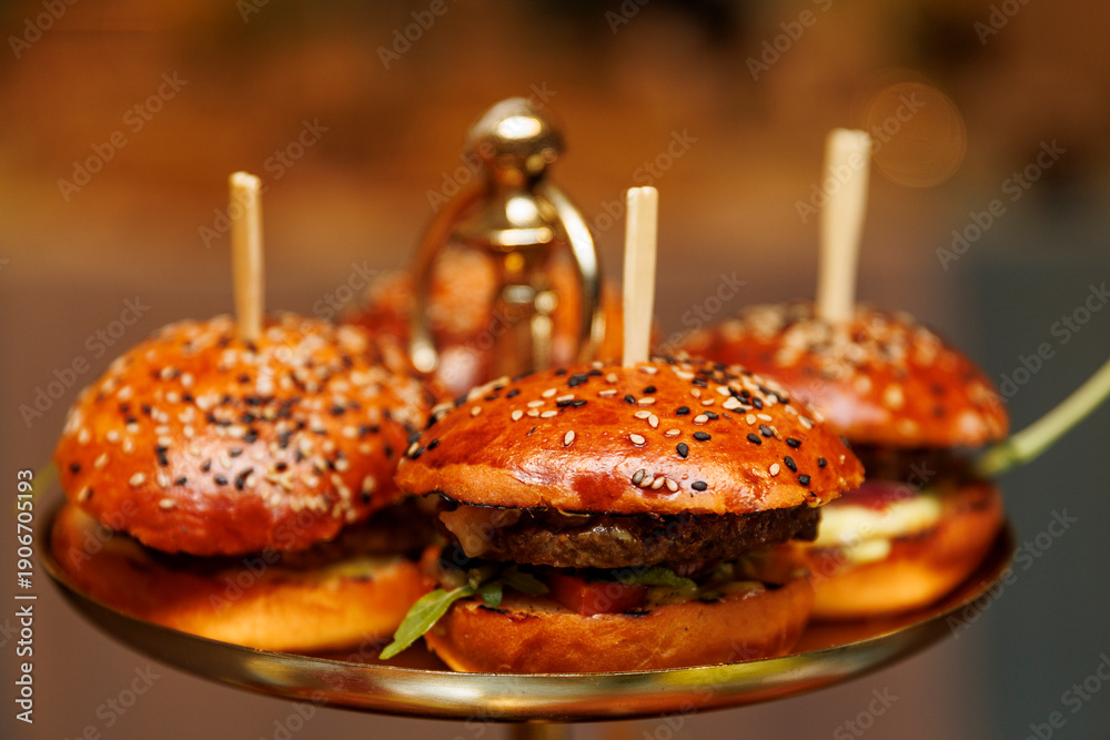 © 9parusnikov - Mini sesame burgers served on golden platter