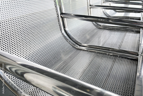 perforated stainless steel waiting bench in public transit station close up