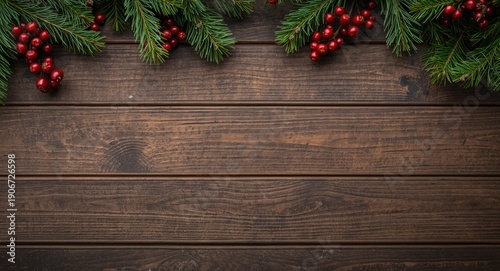 Flat lay of a dark rustic wood texture adorned with holiday fir sprigs and berries for seasonal designs with toned copy space