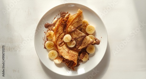 Wallpaper Mural Delicious chocolate and banana crepes arranged on a white plate with copy space from above Torontodigital.ca