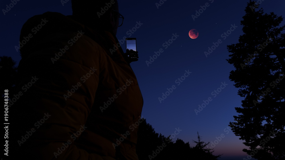 Fototapeta premium Amateur astronomer with smartphone photographing and observing stars, planets, Moon and other celestial objects.