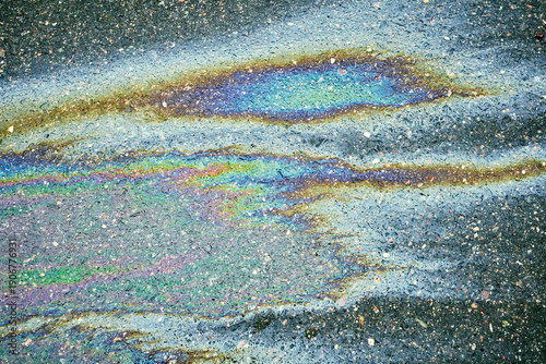 Bild auf Leinwand Oil spill on wet asphalt surface creating colorful iridescent rainbow patterns