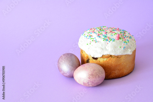 Canvastavla traditional Easter Kulich with colorful Sprinkles and Pastel Eggs on lilac backd