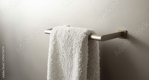 Fluffy white towel hanging on a modern steel towel holder