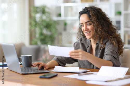 Slika na platnu Happy freelancer checking bills and doing online accounting