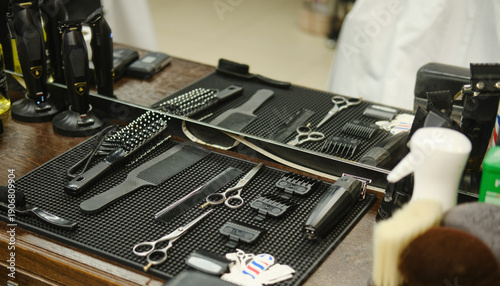 Billede på lærred Professional barber workstation with hair clippers, scissors, combs, brushes and