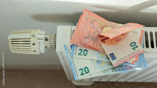 Wallpaper Mural Radiator with euro notes highlights heating costs, heating bills surge in Europe, heating anxiety pushes families to save energy, utilities, inflation, home finance concept Torontodigital.ca