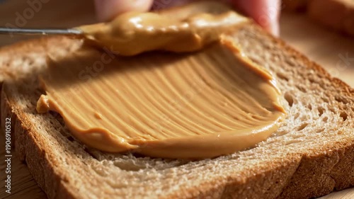 Spreading Peanut Butter on Toast with a Knife for a Delicious Breakfast.