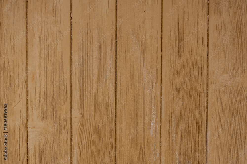 Fototapeta premium A close-up photograph of weathered wooden planks with fine sand visible in the gaps between the boards, the natural grain, knots, and warm tones of the wood in bright, directional sunlight