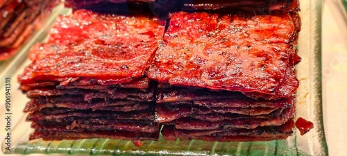 Tableau sur toile Glazed grilled meat slices, Chinese pork jerky arranged in tidy stacks on a glass tray