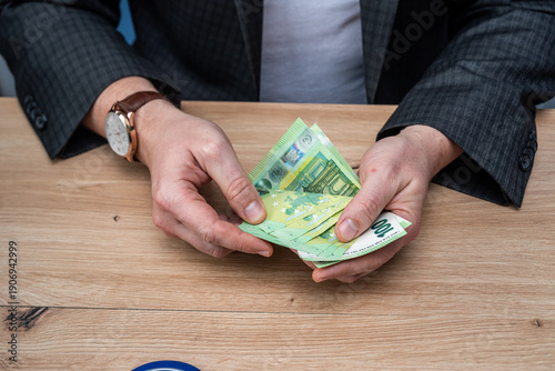 Wallpaper Mural Businessman in Suit Counting One Hundred Euro Banknotes on Wooden Table for Investment Growth Torontodigital.ca