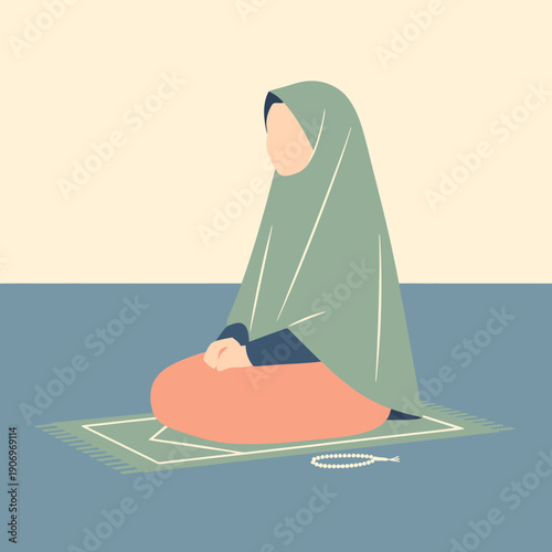 A woman in hijab sitting on prayer mat.